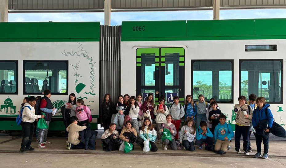 Foto de familia de los alumnos participantes en el programa junto al Tranvía de la Bahía de Cádiz.