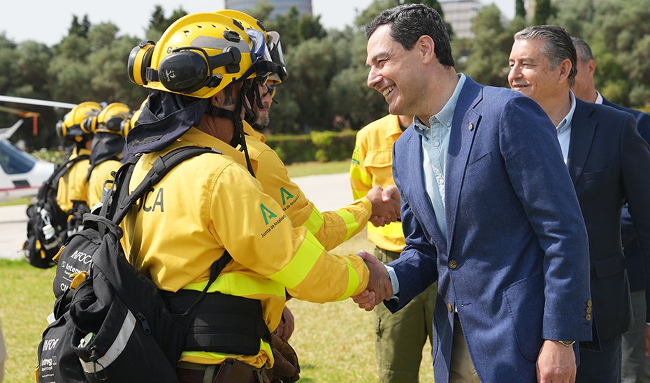 Juanma Moreno shakes hands with one of the Infoca professionals.