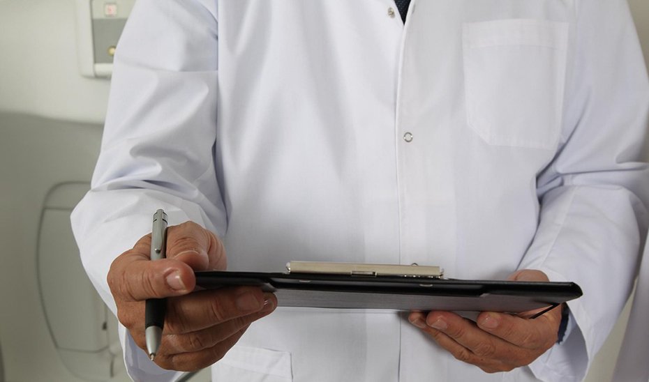 Un médico recoge datos de un paciente.