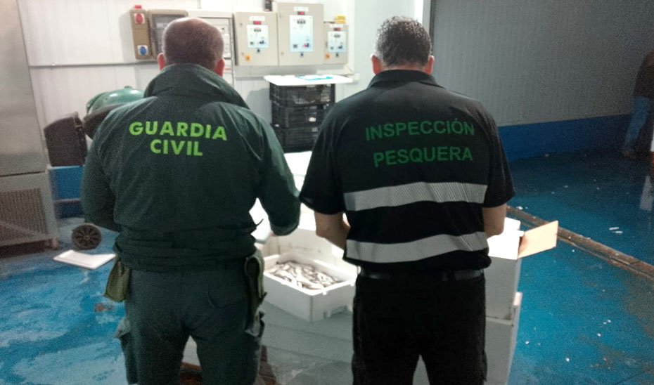 Agentes observan la mercancía decomisada.